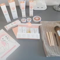 Photo d'une table d'esthéticienne, avec des produits de soins (type crèmes et lotions) et de maquillage (type pinceaux, blush, faux cils...) posés dessus... pour illustrer l'aspect beauté de la socio-esthétique